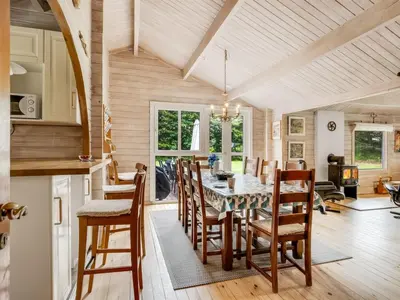 a kitchen and dining room with a table and chairs at Holiday Home Aisling - 700m from the sea by Interhome in Brovst