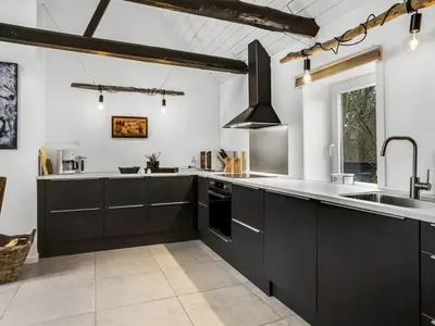 a kitchen with black cabinets and a sink at Apartment Thorgot - 3km from the sea by Interhome in Pandrup