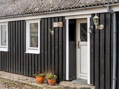 a black house with a door and a sign on it at Apartment Thorgot - 3km from the sea by Interhome in Pandrup