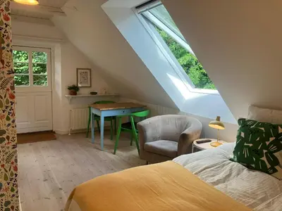 a bedroom with a bed and a table and a chair at Krogsgaarden B&B in Nibe