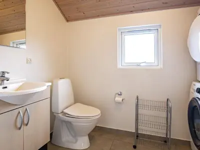 a bathroom with a toilet and a sink and a window at 14 person holiday home in Højslev in Sundstrup
