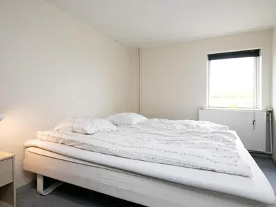 a white bedroom with a bed and a window at 14 person holiday home in Løgstør-By Traum in Løgstør