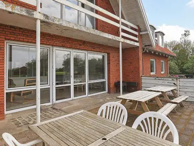 a patio with a picnic table and chairs and a building at Rustic Retreat in Gettrup - By Traum Ferienwohnungen in Sindrup