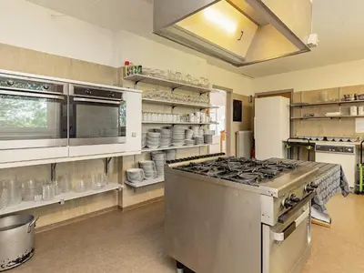 a kitchen with a stove and shelves with dishes at Rustic Retreat in Gettrup - By Traum Ferienwohnungen in Sindrup