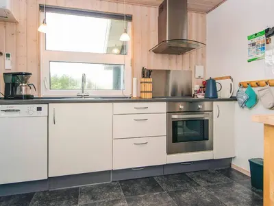 a kitchen with white cabinets and a window at Seaside Escape with Swing in Vrist