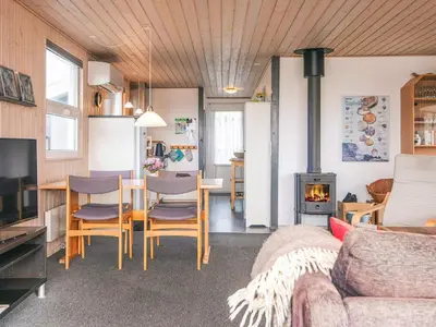 a living room with a table and chairs and a stove at Seaside Escape with Swing in Vrist