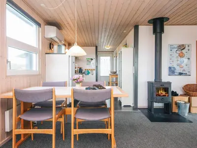a dining room with a table and chairs and a wood stove at Seaside Escape with Swing in Vrist