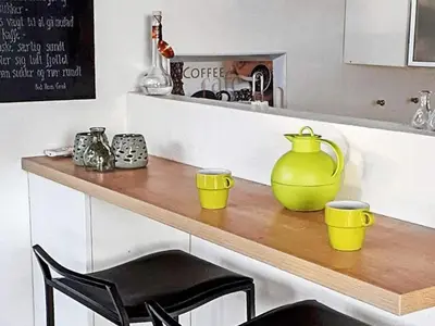 a kitchen counter with a yellow pitcher and two chairs at 6 person holiday home in Struer-By Traum in Remmer Strand
