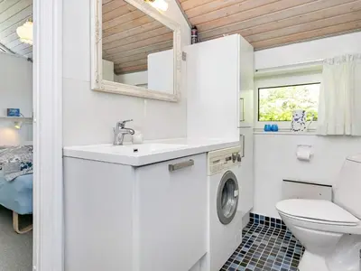 a bathroom with a sink and a washing machine at 6 person holiday home in Struer-By Traum in Remmer Strand