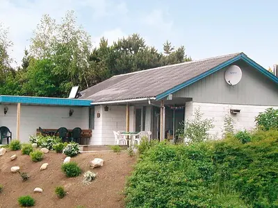a white house with a blue roof and a yard at 8 person holiday home in Spøttrup-By Traum in Lihme