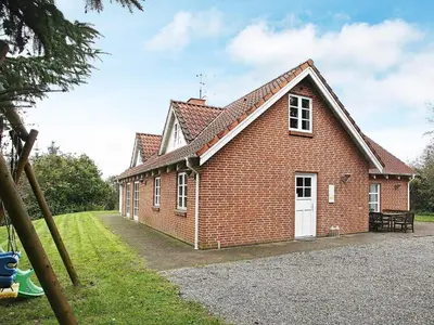 a red brick building with a white door at 10 person holiday home in Fur-By Traum in Fur