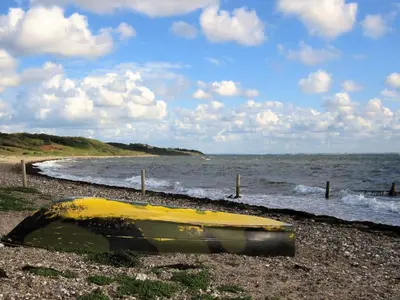 a yellow boat sitting on a beach next to the ocean at 6 person holiday home in Spøttrup-By Traum in Lihme
