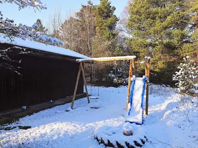 a swing set in a yard covered in snow at 12 person holiday home in Pandrup-By Traum in Rødhus