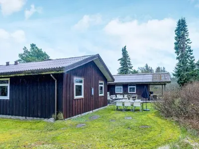 a cabin with a table and chairs in a yard at 12 person holiday home in Pandrup-By Traum in Rødhus
