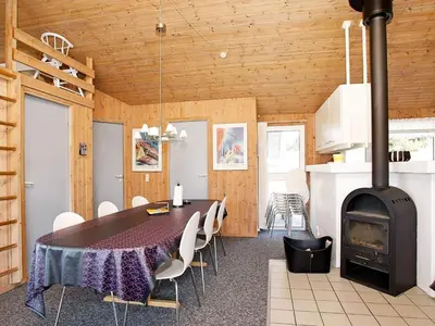 a dining room with a table and a wood stove at Luxury Pool Villa Retreat - By Traum Ferienwohnungen in Blokhus