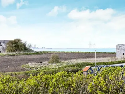 a view of a beach with a windmill in the distance at 4 person holiday home in Lemvig-By Traum in Lemvig