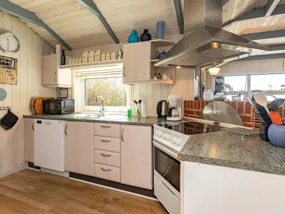 a kitchen with white cabinets and a counter top at Fjordview Retreat with Spa - By Traum Ferienwohnungen in Sillerslev
