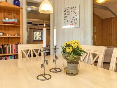 a table with two candles and a vase of flowers on it at Fjordview Retreat with Spa - By Traum Ferienwohnungen in Sillerslev