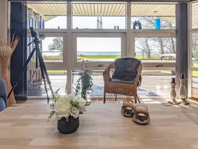 a living room with a camera and a chair and flowers at Fjordview Retreat with Spa - By Traum Ferienwohnungen in Sillerslev
