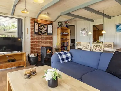 a living room with a blue couch and a table at Fjordview Retreat with Spa - By Traum Ferienwohnungen in Sillerslev