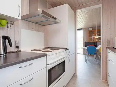 a kitchen with a white stove top oven next to a table at 7 person holiday home in Struer-By Traum in Remmer Strand