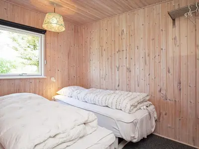 two beds in a room with wooden walls at 7 person holiday home in Struer-By Traum in Remmer Strand