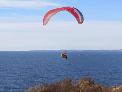 a person riding a parachute over the ocean at 7 person holiday home in Struer-By Traum in Remmer Strand