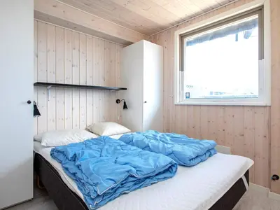 a large bed in a room with a window at Panoramic Sea View Retreat - By Traum Ferienwohnungen in Blokhus