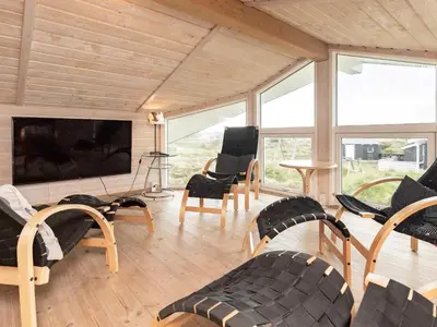 a living room with chairs and a flat screen tv at 10 person holiday home in Thisted-By Traum in Klitmøller
