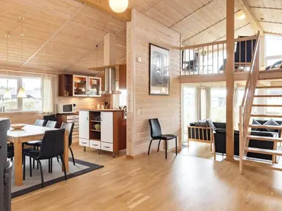a living room with a table and chairs and a kitchen at 10 person holiday home in Thisted-By Traum in Klitmøller
