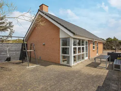 a red brick house with a large window at 8 person holiday home in Vestervig-By Traum in Vestervig