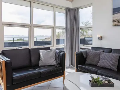 a living room with two black leather couches and a table at 8 person holiday home in Vestervig-By Traum in Vestervig