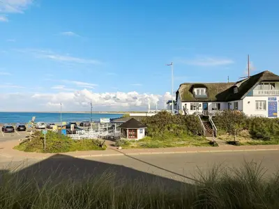 a house on the side of a road next to the ocean at Tranquil Retreat in Klitmoller - By Traum Ferienwohnungen in Klitmøller
