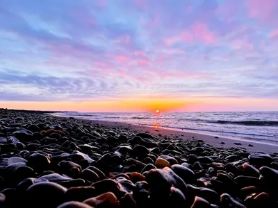 a group of rocks on a beach at sunset at Luxury Retreat with Pool - By Traum Ferienwohnungen in Torup Strand