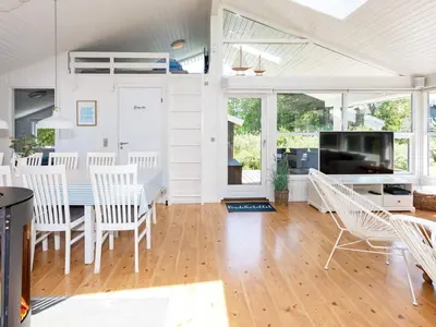 a dining room and living room with a table and chairs at Luxury Retreat with Pool - By Traum Ferienwohnungen in Torup Strand