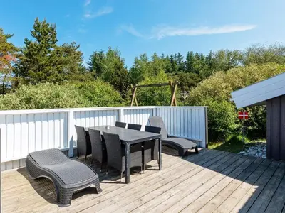 a patio with a table and chairs on a deck at Luxury Retreat with Pool - By Traum Ferienwohnungen in Torup Strand