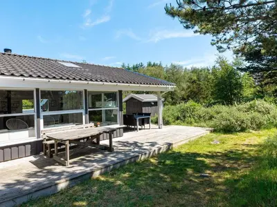 a house with a picnic table on a deck at Luxury Retreat with Pool - By Traum Ferienwohnungen in Torup Strand