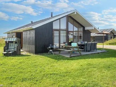 a small house with a table and chairs in the yard at 7 person holiday home in Ulfborg-By Traum in Thorsminde