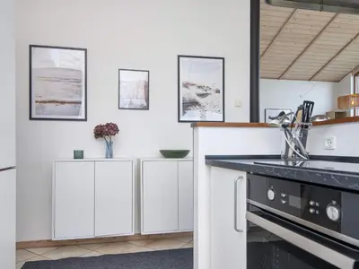 a kitchen with white cabinets and a black counter top at 7 person holiday home in Ulfborg-By Traum in Thorsminde