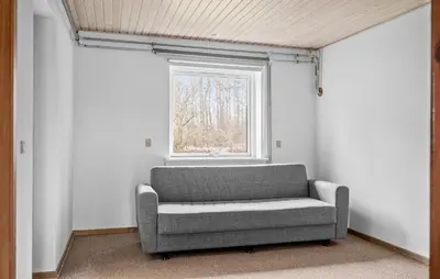 a gray couch in a room with a window at Lovely Home In Vemb With House Sea View in Vemb