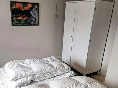 a bedroom with two unmade beds and a cabinet at 4 person holiday home in Lemvig-By Traum in Trans