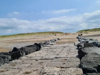 a stone path on a beach with rocks at 4 person holiday home in Lemvig-By Traum in Trans