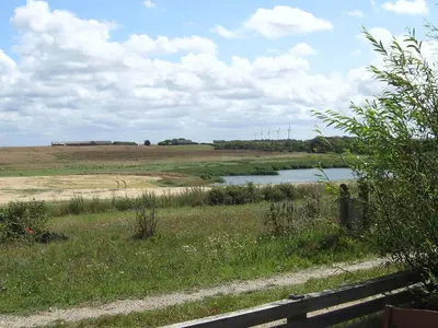 a river in a field with a train in the distance at 4 person holiday home in Lemvig-By Traum in Trans