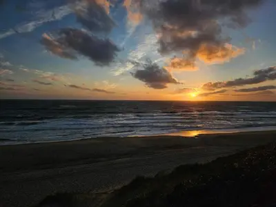 a sunset on a beach with the ocean at 8 person holiday home in Ulfborg in Thorsminde
