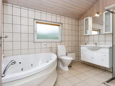 a bathroom with a tub and a toilet and a sink at 6 person holiday home in Harboøre-By Traum in Harboør