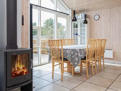 a dining room with a table and a fireplace at Luxury Eco Cottage in Klitmoller - By Traum Ferienwohnungen in Klitmøller