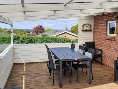 a patio with a table and chairs on a deck at 10 person holiday home in Roslev in Flovtrup