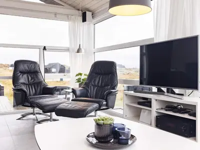 a living room with two chairs and a flat screen tv at Luxury Beachfront Retreat - By Traum Ferienwohnungen in Rødhus