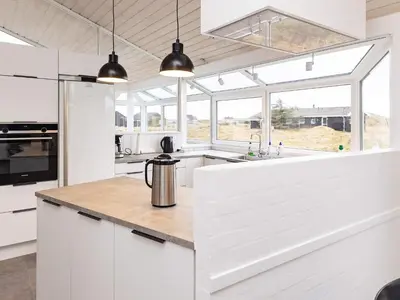 a kitchen with white cabinets and a counter top at Luxury Beachfront Retreat - By Traum Ferienwohnungen in Rødhus
