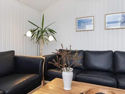 a living room with black leather couches and a table at Luxury Retreat near Beach - By Traum Ferienwohnungen in Blokhus